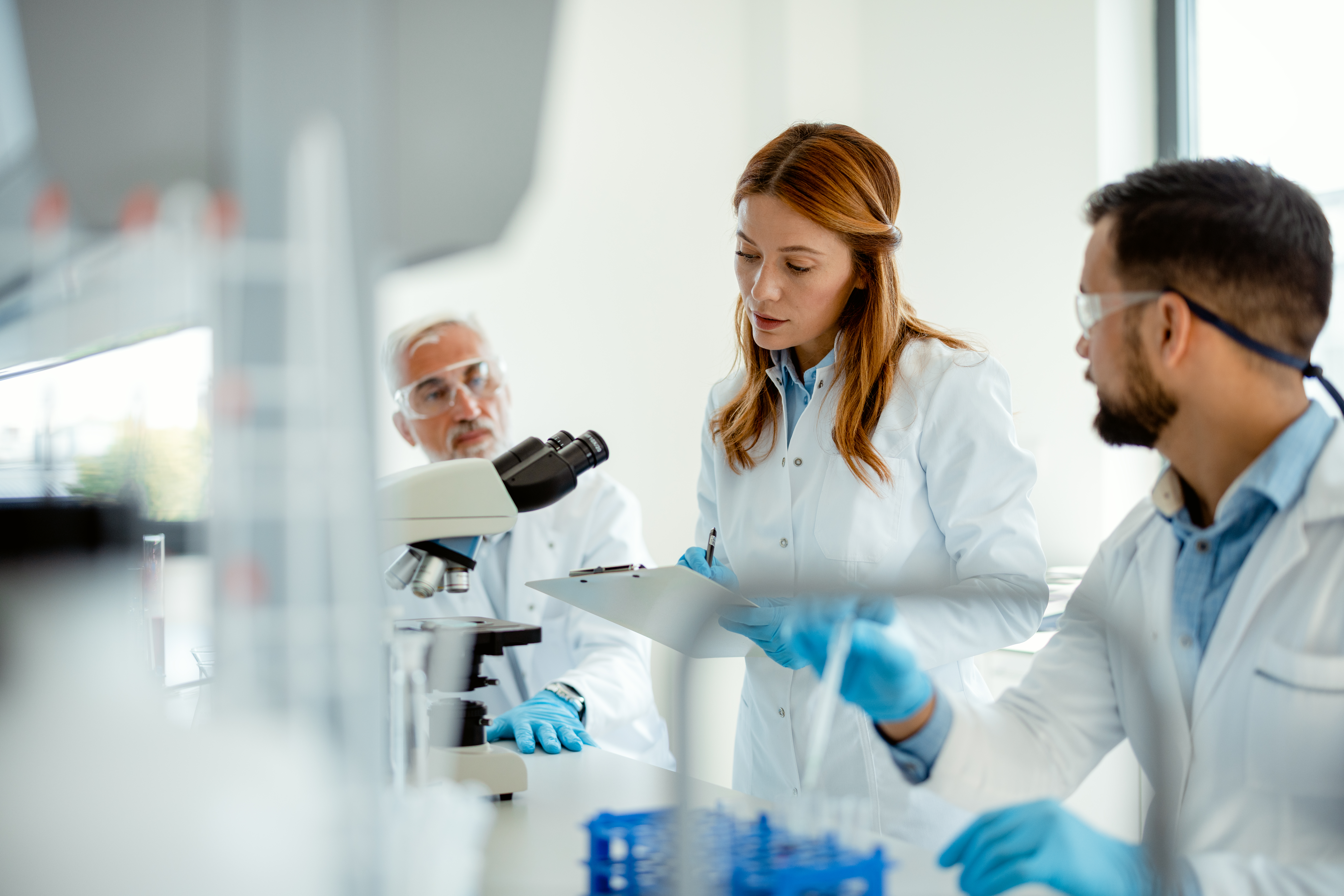 Group of professional researchers in modern medical laboratory studying reactions of chemical compounds for quality control and safety testing. Scientists in high-tech research lab conducting chemical experiments and analyzing petrochemical reactions. Concept of precision, safety, and product testing.